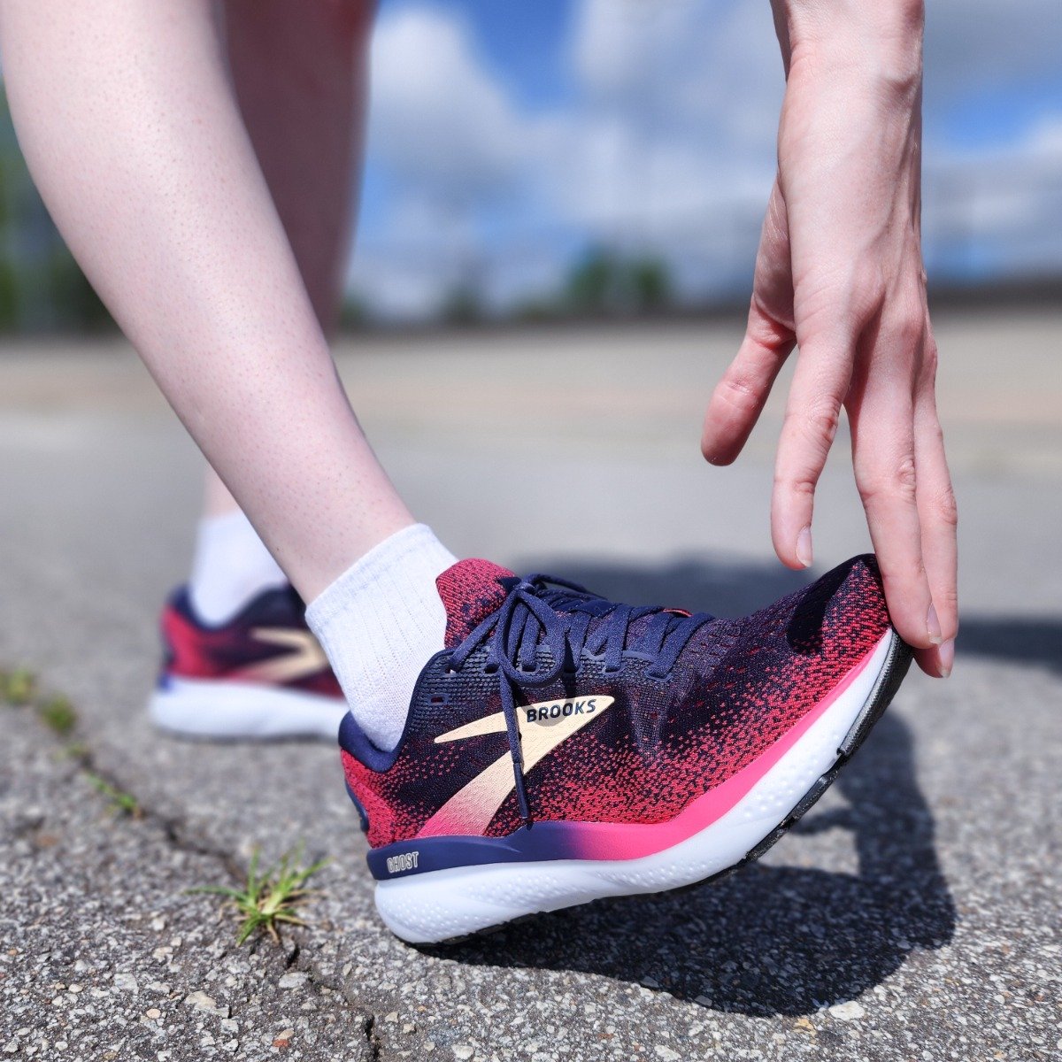 A woman wearing Brooks shoes stretching.