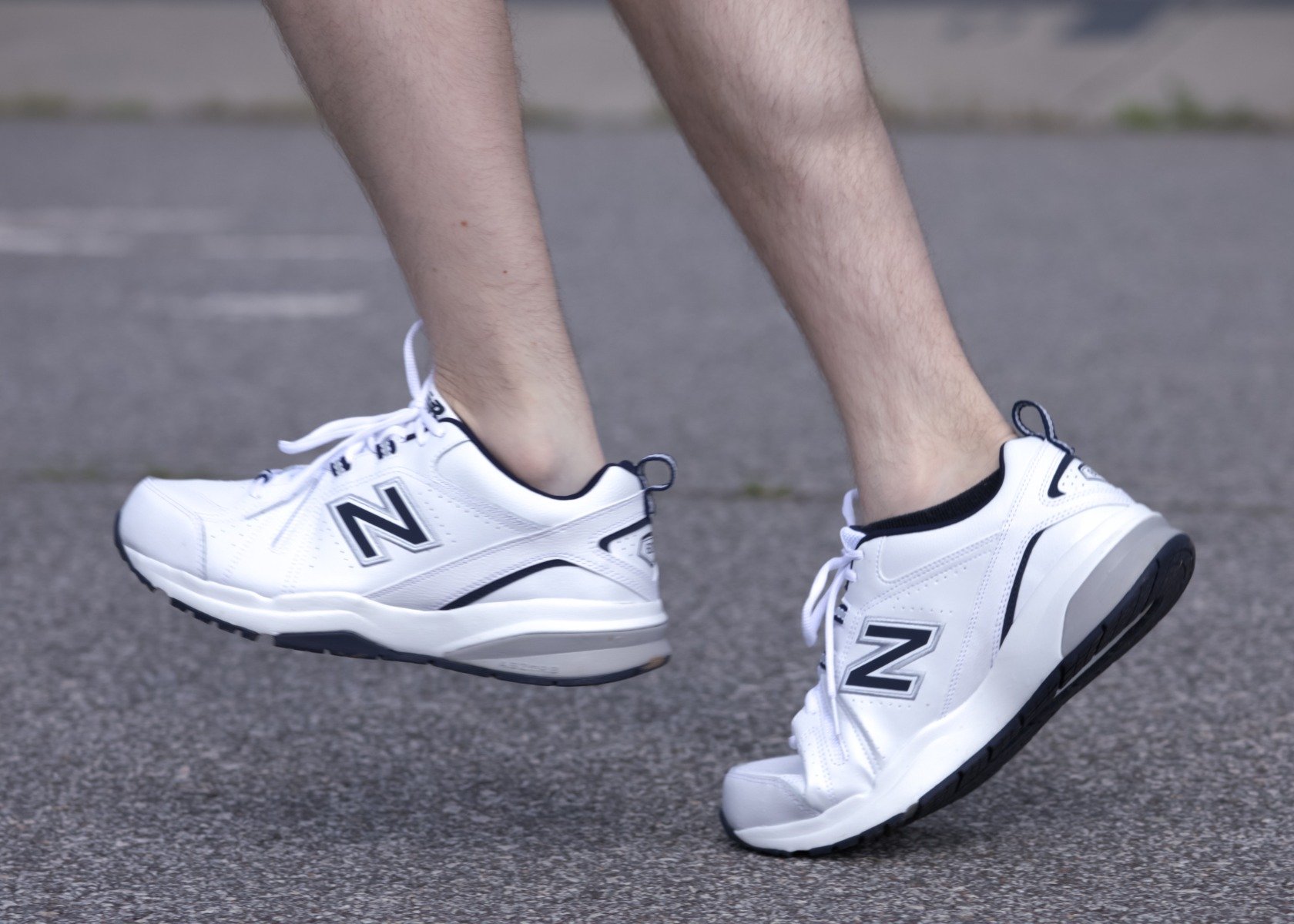 A man wearing white new balance sneakers is running.